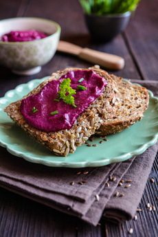 Dunkle Brotscheibe mit Aufstrich aus Roter Bete