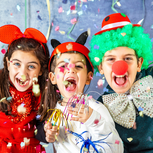 Kinder in bunten Faschingskostümen verkleidet feiern Karneval